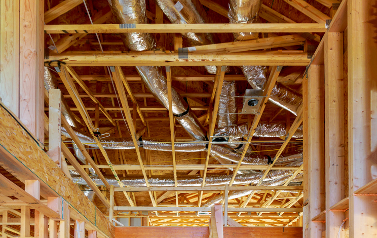 Ventilation pipes in silver insulation material the ceiling inside new stick built home under construction